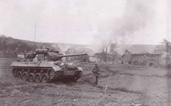 Hellcat with walking GI in front of a burning town. This photo was identified by its driver Sgt. Harry E. Traynor of the 704th TD Bn. The soldier in the front is Cpt. Marion Taake, The TD was named “Blondie” and it was later destroyed on February 9, 1945 by two German Panther tanks in the Bannholz Woods area of Germany.