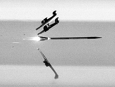 A modern APFSDS-T projectile shortly after muzzle exit, as the sabot petals are separating from the penetrator.