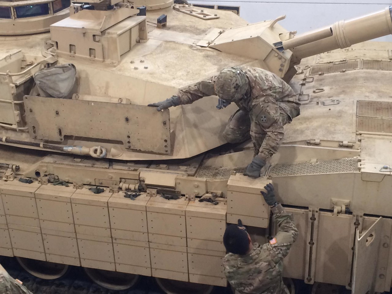 Tank and maintenance crews with 1st Battalion, 66th Armor Regiment, install reactive armor tiles onto a M1A2 Abrams tank.