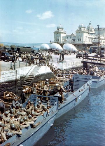 US Army soldiers boarding landing craft at Weymouth, Dorset, England, United Kingdom, while preparing for the Normandy operation, 1 May 1944; note barrage balloons aloft and on the ground.