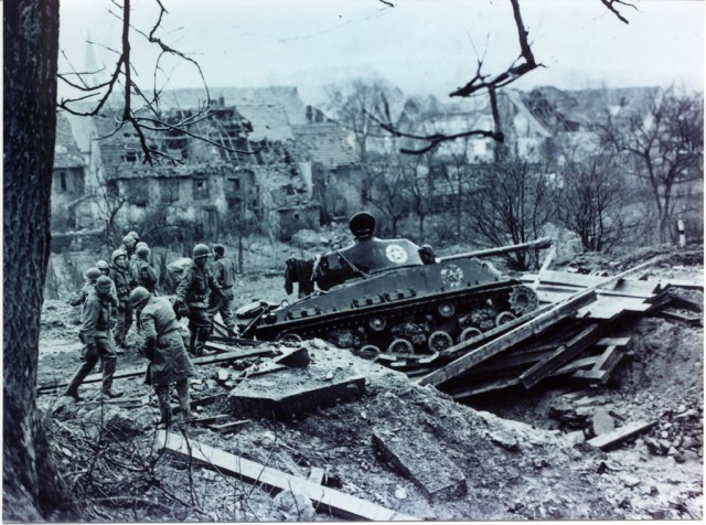 M4A3E8 tank on a bridge that collapsed with weight of vehicle during operation Grosblieberstroff on the Saar. Tank is from 749th Tank Battalion. Dated February 18, 1945.