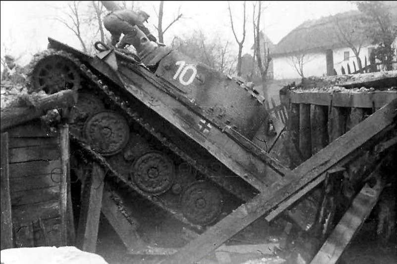 A Tiger I from Schwere Panzer-Abteilung 506 after falling through a bridge, 1945.
